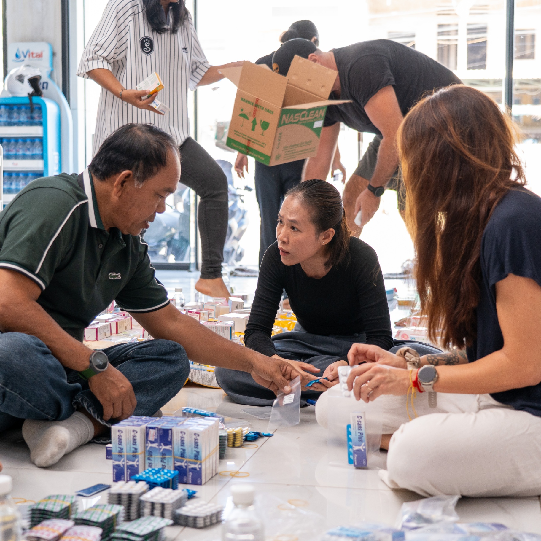 Volunteers organising medicine and supplies into relief packages in Cambodia